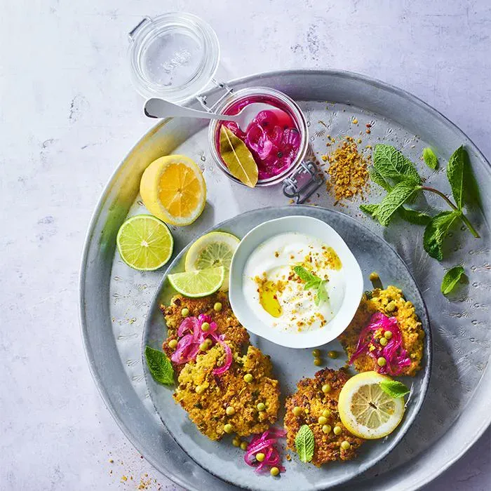 Image représentant Galettes de Petits Pois et boulgour au curry, pickles d'oignons rouge, menthe fraiche et yaourt grec aux 2 citrons