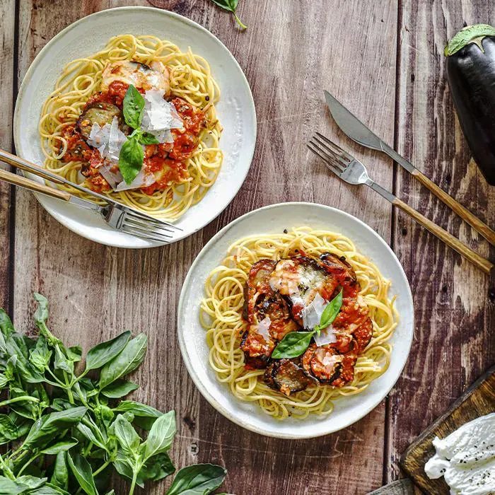 Image représentant Aubergines à l’italienne, nid de spaghettis, parmesan, basilic frais.